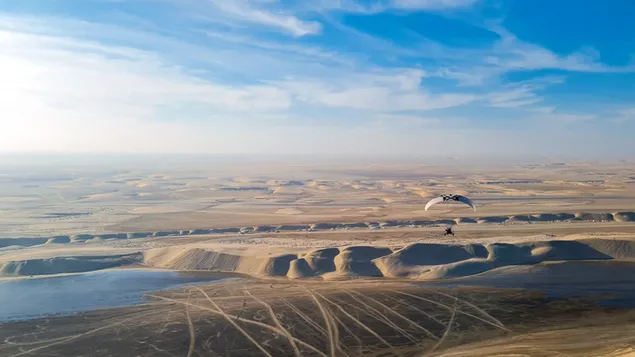 Paragliden boven de uitgestrekte woestijn download