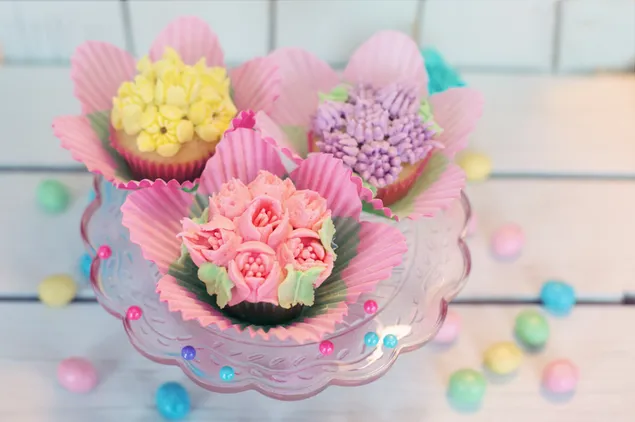 パステルカラーの花のデザインのカップケーキとイースターエッグ