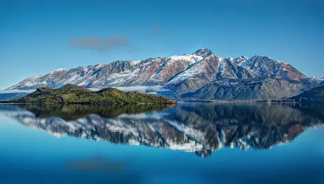 Perfekte Reflexion von schneebedeckten Bergen und Bäumen im Seewasser im Freien