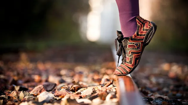 Person som står på tuppen av lange lilla sokker og fargerike mønstrede sko på tåkete i uskarp bakgrunn 2K bakgrunn