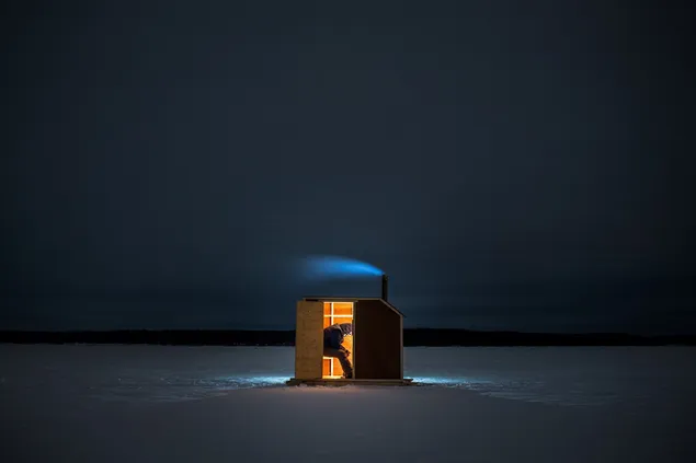 Persona calentándose en carpa con estufa ardiente sobre hielo en la naturaleza por la noche
