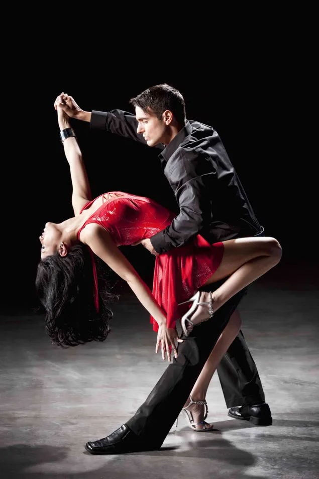 Pertunjukan tango yang penuh gairah dari wanita dengan rambut hitam panjang dengan gaun merah dan pria dengan gaun hitam unduhan