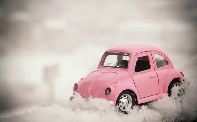 Pink Volkswagen Bug coche en miniatura en la nieve.