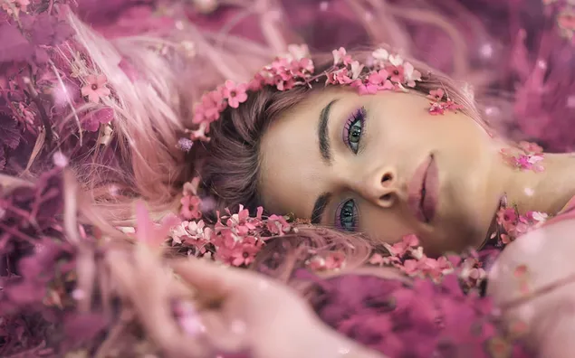 ピンクの花の上に横たわっている美しい少女