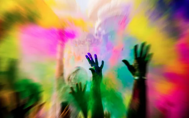 Pintura coloreada del festival holi esparcida en el aire, manos felices