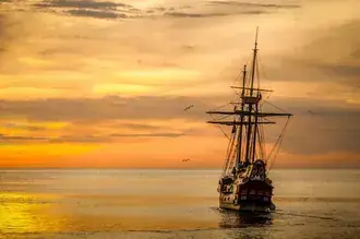 pirate ship at sundown 2K wallpaper