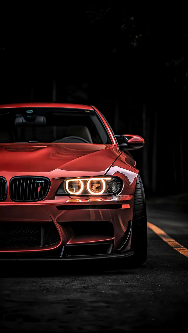 سدان اسپرت قرمز قدرتمندی که زیر نور غروب دلگیر در جاده‌ای متروک می‌درخشد کاغذدیواری  2K