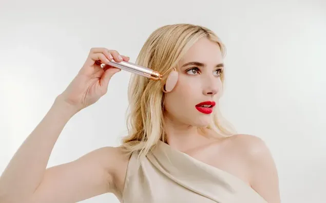 Pretty and  sexy actress Emma Roberts red lips and holding a jade roller 