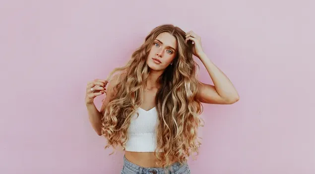 Pretty curly blonde girl with pink background 