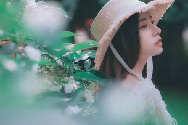 Pretty face of Asian girl wearing straw hat 