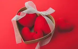 Tapeta Nafouklé červené srdce v dárkové krabičce ve tvaru srdce s roztomilou bílou stuhou - den svatého Valentýna 2K