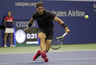 rafael nadal running to the tennis ball in a black t-shirt and red shoes download