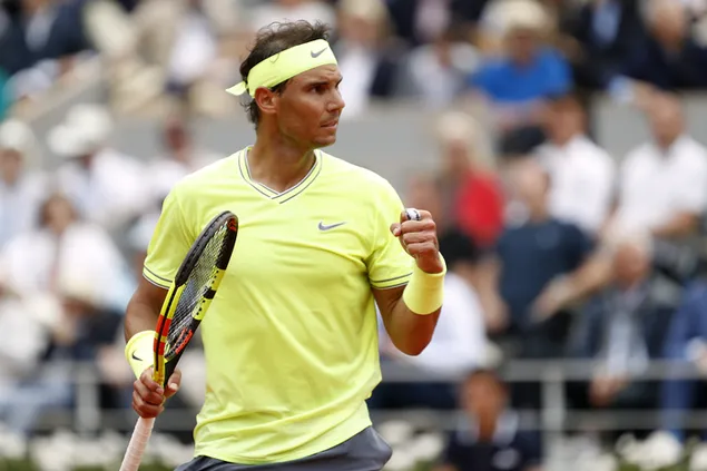 Rafael Nadal während eines Tennisspiels mit ihrem gelben T-Shirt herunterladen