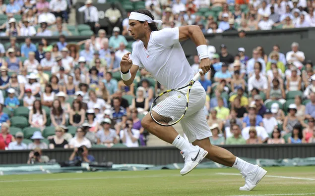 Rafael Nadal, weißes T-Shirt und weiße Shorts, die laufen, um den Ball zu treffen