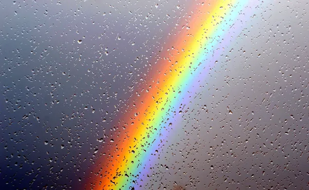 Regndråber samler sig på glasset og en sløret regnbue bag glasset 2K tapet