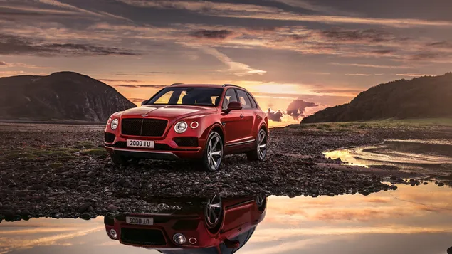 Muat turun Bentley Bentayga merah dengan latar belakang matahari terbenam yang indah