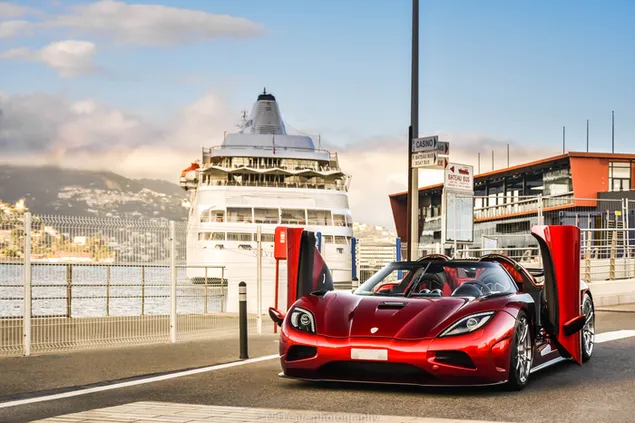 Преземете Црвениот спортски автомобил Koenigsegg Agera паркиран покрај патот