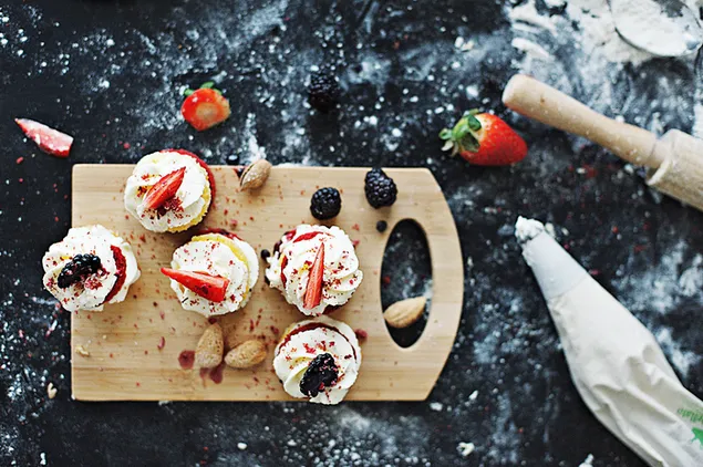 Cupcakes de terciopelo rojo con toppings de fresa y frambuesa 4K fondo de pantalla