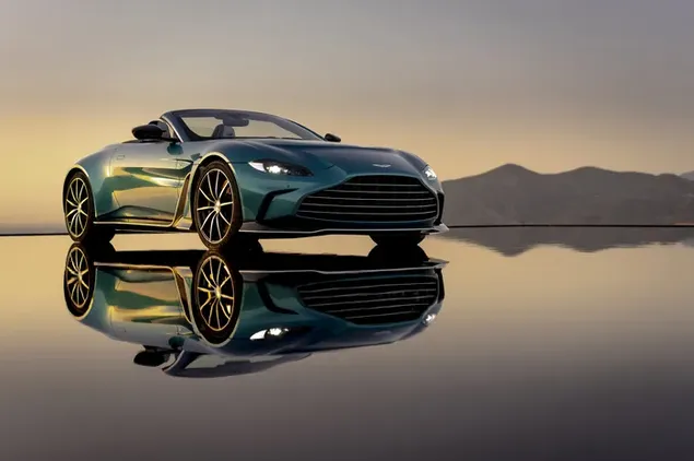 Reflejo del coche deportivo verde oscuro Aston Martin en el paisaje de siluetas de montaña bajo un cielo despejado descargar