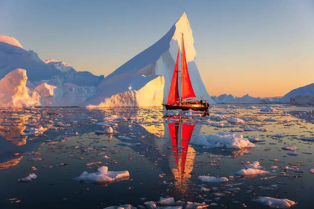 Reflection of huge glaciers and red sailboat in cold icy water