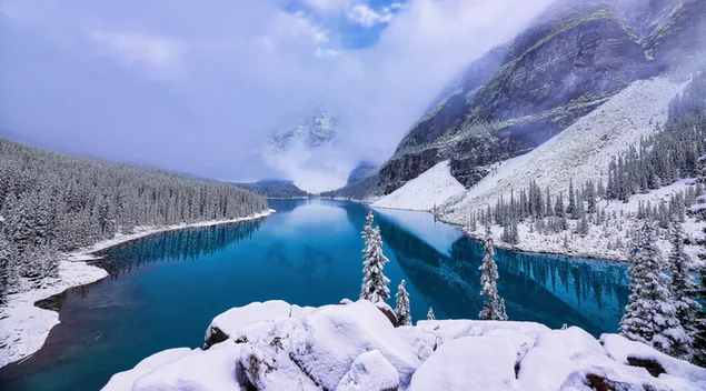 Reflexion von nebligen schneebedeckten Bergen im See 4K Hintergrundbild