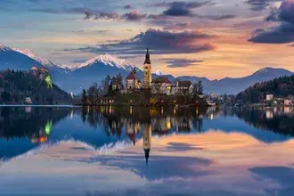Refleksi gunung dan awan di atas air dengan gereja perawan maria 2K wallpaper