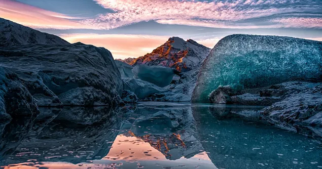 انعكاس شروق الشمس من خلف الصخور في المناظر الطبيعية الملبدة بالغيوم في الماء 4K خلفية