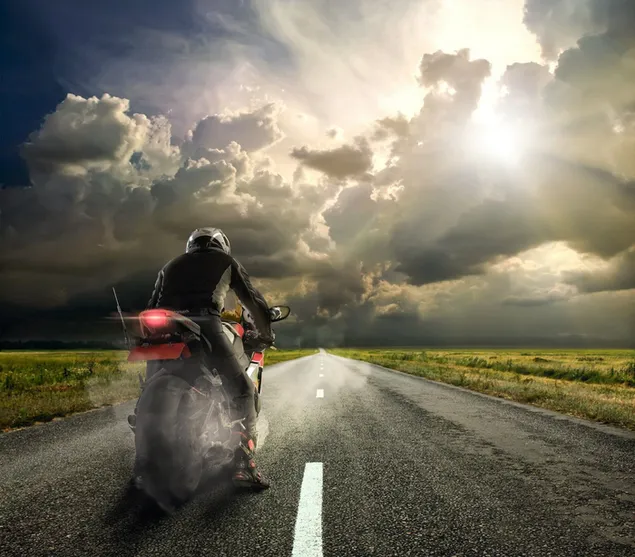 Rytter på en sort og rød motorcykel iført hjelm på en asfalt 2K tapet