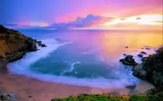 Rocks and plants on the beach around the sea water reflected in the yellow rays of the sun among the clouds 2K wallpaper