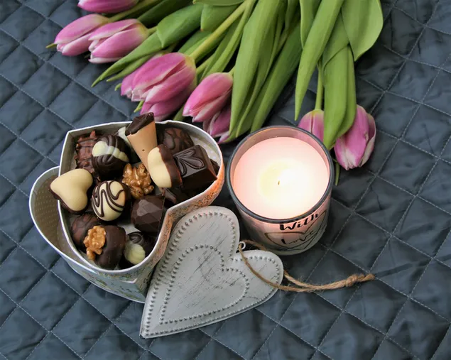 Rosa Tulpen, Pralinen und Kerzen, um Valentinsgrüße willkommen zu heißen