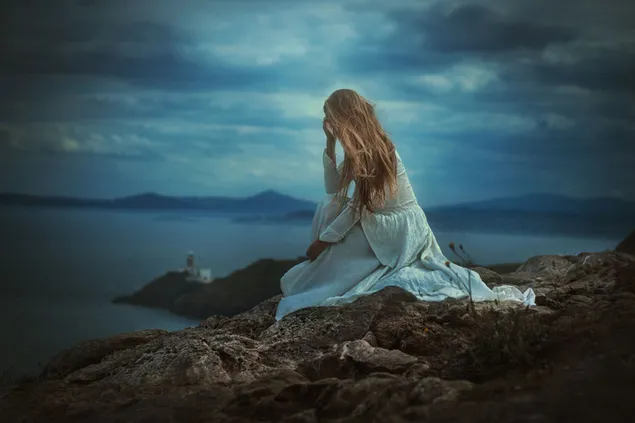 岩の上に座っている悲しい少女