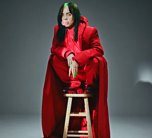 Sängerin Billie Eilish trägt ein rotes Outfit und isst Kaugummi