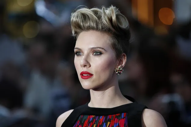 Scarlett johansson met haar blonde haren opgestoken, rode lippen, blauwe ogen en prachtige oorbellen