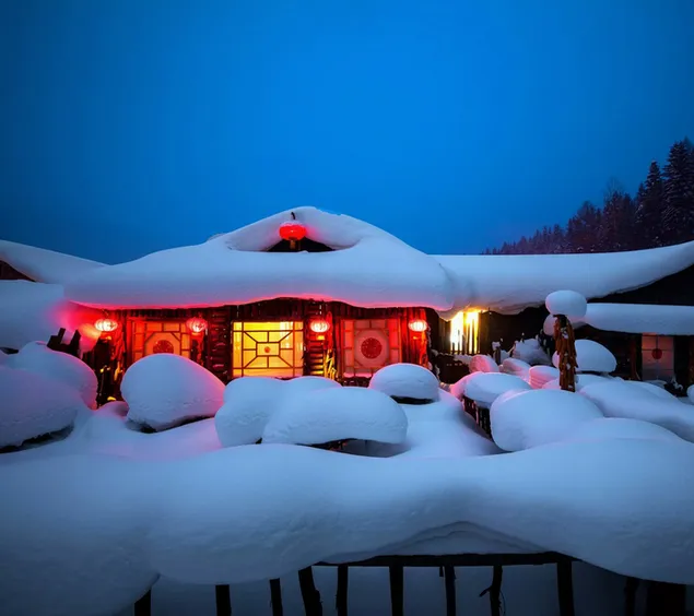Schneebedecktes Haus mit farbigen Lichtern