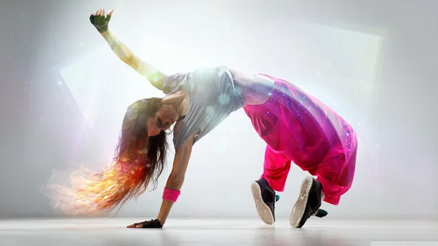Schöne Tänzerin, eingetaucht in den Rhythmus der Musik in ihrem langen Haar und rosa Tanzoutfit