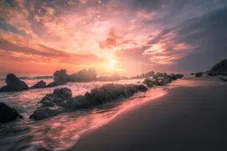 Sea sand and cliffs under cloudy and sunny sky 2K wallpaper
