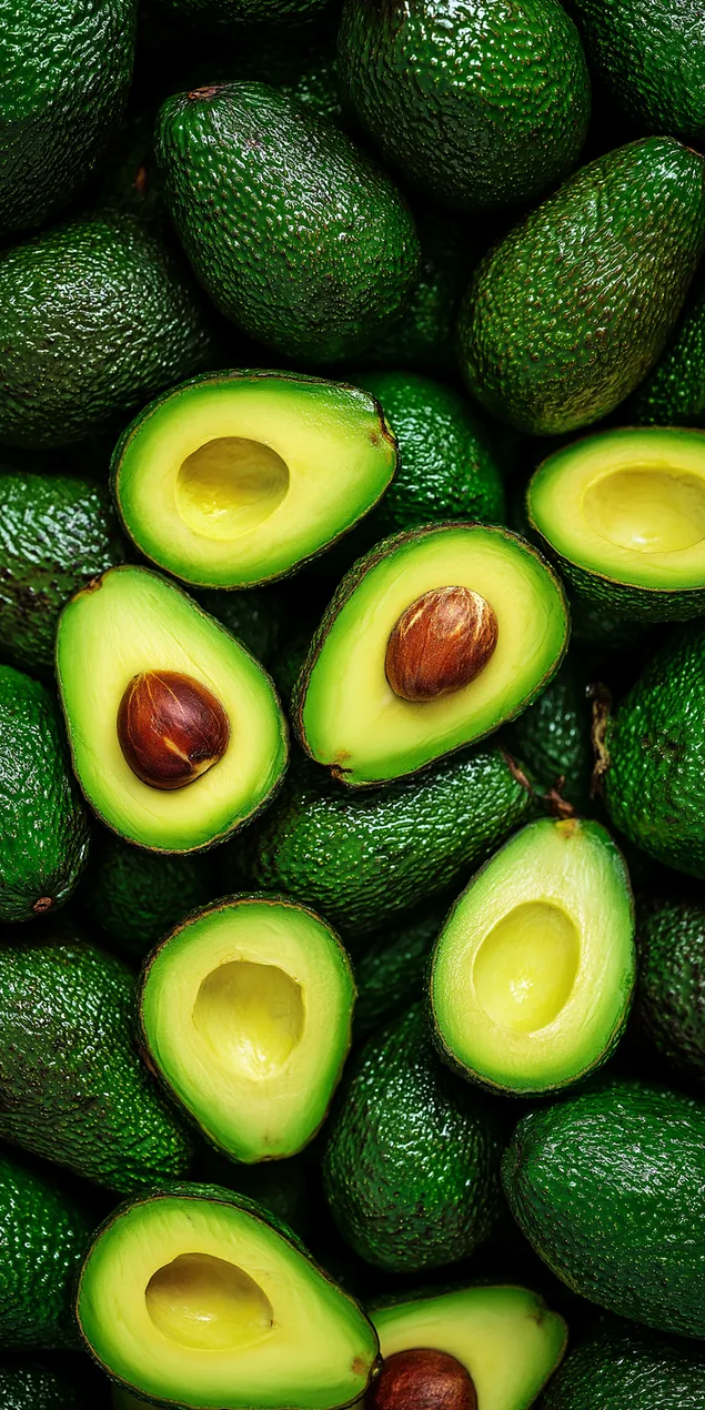Taustakuva Saumaton tausta tuoreista kypsistä kokonaisista ja puolitetuista avokadoista HD