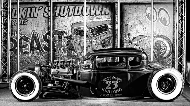 Sebuah mobil klasik antik berdiri di depan dinding yang didekorasi dengan grafiti