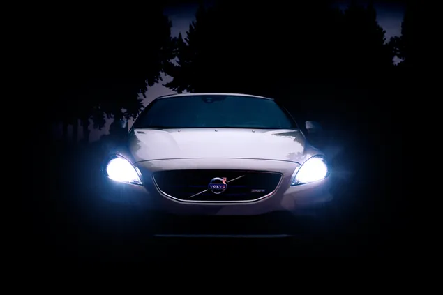 Zilveren Volvo-auto met koplampen aan 's nachts download