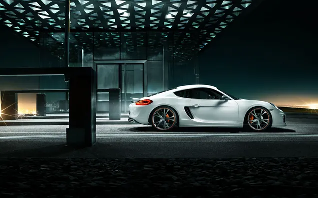 Single-door Porsche Taycan with black steel rim design in white color photographed in front of the building at night