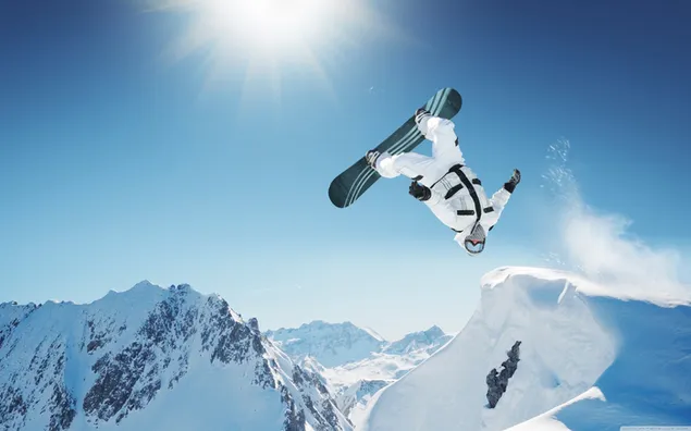 Skiër doen akrobatiese koel poses op hoë sneeuheuwels naby die son aflaai