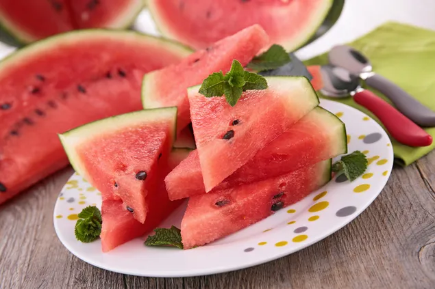 Wassermelone auf einem Teller in Scheiben schneiden