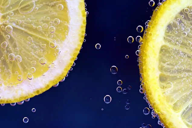 Geschnittene Zitrone und Wasser mit Wassertropfen herunterladen