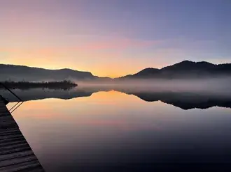 Glatko jezero u zalasku sunca s oblacima magle 4K pozadina