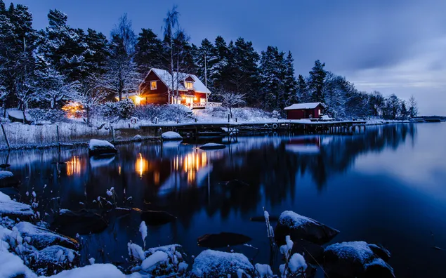 Snowy forest and lake view of wooden house at night 4K wallpaper