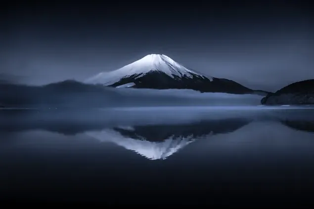 Schneebedecktes Bild des Anime-Berges Fuji spiegelt sich nachts im Wasser wider