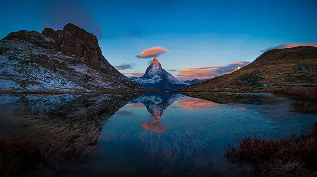 ยอดเขาที่ปกคลุมด้วยหิมะและภาพสะท้อนของท้องฟ้าใสในน้ำในทะเลสาบใส 8K วอลเปเปอร์