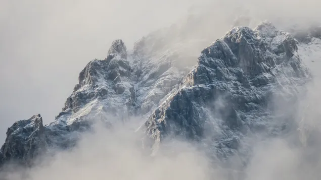 霧の中で雪に覆われた岩の峰