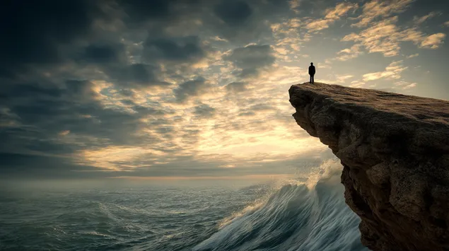 Eenzame figuur kijkt uit over de brekende golven vanaf de rand van de klif 2K achtergrond