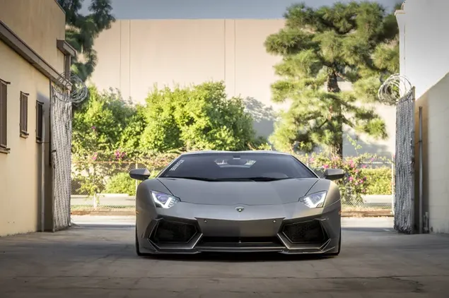 Spectacular gray Lamborghini parked between buildings in the sunny outdoors